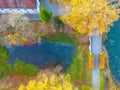 Beautiful travel or tourism style look down aerial of pedestrian foot bridge across River at park with colorful fall foliage