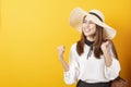 Beautiful traveler woman is exciting on yellow background