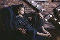 Beautiful trendy teen boy sitting on a chair at home Royalty Free Stock Photo