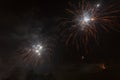 Beautiful trio of golden and white fireworks over trees silhouette