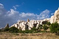 Beautiful troglodytes of rocky desert rose valley in blue sky with clouds Royalty Free Stock Photo