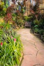 Beautiful tropical asia style with green red color garden idea with wooden chair, concrete pavement and bamboo wall. Royalty Free Stock Photo