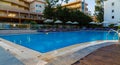 Beautiful tropical beach front hotel resort with swimming pool, sun-loungers and palm trees during warm sunny day, paradise Royalty Free Stock Photo