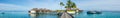 Beautiful tropical beach panorama of bungalos with bridge near the ocean with palms trees and boats at Maldives Royalty Free Stock Photo