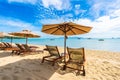 Beautiful tropical beach sea and ocean with coconut palm tree  and umbrella and chair on blue sky and white cloud Royalty Free Stock Photo