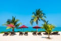 Beautiful tropical beach sea ocean with umbrella and chair around coconut palm tree on blue sky Royalty Free Stock Photo