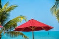 Beautiful tropical beach sea ocean with umbrella and chair around coconut palm tree on blue sky Royalty Free Stock Photo