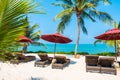 Beautiful tropical beach sea ocean with umbrella and chair around coconut palm tree on blue sky Royalty Free Stock Photo