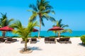 Beautiful tropical beach sea ocean with umbrella and chair around coconut palm tree on blue sky Royalty Free Stock Photo