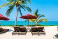 Beautiful tropical beach sea ocean with umbrella and chair around coconut palm tree on blue sky Royalty Free Stock Photo