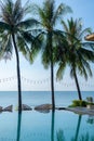 Beautiful tropical beach and sea with palm tree, coconut tree and chair around swimming pool in hotel resort for travel and Royalty Free Stock Photo