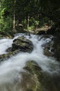 Beautiful tropical cascading river flowing surrounded by green f