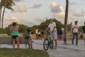 Beautiful tropical landscape view. People changing after visiting beach and some people with bicycles on green trees.