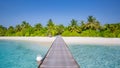 Wooden pier into paradise island in Maldives. Tranquil amazing nature landscape, sand palm trees blue sunny sky, pristine sea Royalty Free Stock Photo