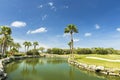 Beautiful tropical natural landscape view. Green grass field and pond water surface on blue sky with rare white clouds background Royalty Free Stock Photo