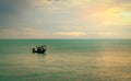 Beautiful tropical sea in the morning with golden sunrise sky. Fisherman in long tail boat with folk fishing culture. Peaceful and