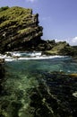 Beautiful tropical seascape with stunning rock texture hitting by soft wave at sunny day. Royalty Free Stock Photo