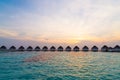 Beautiful tropical sunset over Maldives island with water bungalow in hotel resort Royalty Free Stock Photo