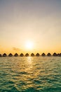 Beautiful tropical sunset over Maldives island with water bungalow in hotel resort Royalty Free Stock Photo