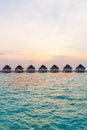 Beautiful tropical sunset over Maldives island with water bungalow in hotel resort Royalty Free Stock Photo