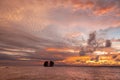 Beautiful tropical sunset over the sea horizon with black silhouette of trees on a little island. Royalty Free Stock Photo