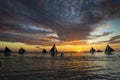 sunset with sailing boats and tourists in boracay island philippines