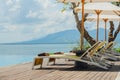 Beautiful tropical swimming pool in hotel or resort with umbrella, coconuts tree sun-loungers, palm trees with infinity pool view Royalty Free Stock Photo