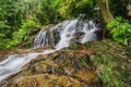 Beautiful tropical waterfall in lush surrounded by green forest.wet rock and moss.