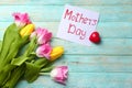 Beautiful tulips and handmade card for Mother\'s Day on wooden background Royalty Free Stock Photo