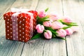 Beautiful tulips with red polka-dot gift box. Royalty Free Stock Photo