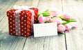 Beautiful tulips with red polka-dot gift box. Royalty Free Stock Photo