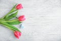 Beautiful tulips and small cotton heart on light wooden background Royalty Free Stock Photo