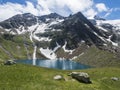 Beautiful turquoise blue mountain lake Grunausee in alpine landscape with green meadow and snow-capped mountain peaks Royalty Free Stock Photo