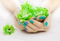 Beautiful turquoise manicure with chrysanthemum and towel on the white wooden table. spa