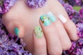 Beautiful turquoise manicure with crystals on female hand. Close-up.