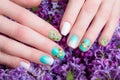 Beautiful turquoise manicure with crystals on female hand. Close-up.