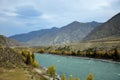 A beautiful turquoise river flows through a picturesque autumn valley surrounded by high mountain ranges Royalty Free Stock Photo