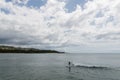 A beautiful Turtle Bay vista on Oahu, with a female longboard surfer in the foreground