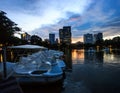 Beautiful Twilight Lake View of Lumpini Park with driving duck boat and modern buildings as background.