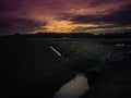 Dramatic twilight landscape over cranberry bog irrigation canal Royalty Free Stock Photo