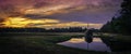 Panoramic dramatic cloudscape at sunset over cranberry field and reflections on the pond on Cape Cod Royalty Free Stock Photo