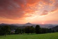 Beautiful twilight sunset landscape. Evening in hills with villages. Sun with ping and orange sky. Evening sun during sunset in Cz