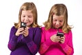 Beautiful twin girls text messaging Royalty Free Stock Photo