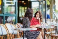 Beautiful twin sisters drinking coffee