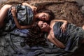 Beautiful twins young women with natural make-up and hair style lying with their curly hair surround them Royalty Free Stock Photo