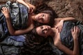 Beautiful twins young women with natural make-up and hair style lying with their curly hair surround them Royalty Free Stock Photo