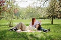 Beautiful two ladies lesbian laying down on the grass in the middle of the park hugging each other and fed in love Royalty Free Stock Photo