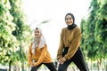 beautiful two Muslim girls in headscarves do lunges movement before outdoor sports