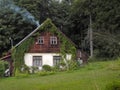 Beautiful two-storied eco cottage with chimney in the forest Royalty Free Stock Photo