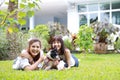 Beautiful two young asian woman wearing white shirt who lying on grass and playing with her cute dog with happy and smiling face Royalty Free Stock Photo